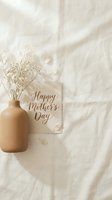 Happy Mothers Day card with dried flowers in a beige ceramic vase on white linen, soft natural light, minimal boho flat lay style.