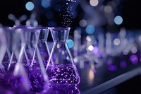 Laboratory glassware with sparkling liquid in purple neon lighting against blurred bokeh background creates magical chemistry atmosphere for science concepts.