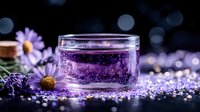 Purple sparkling drink in glass jar with daisy flowers and glitter on dark background with bokeh lights creates magical atmosphere for wellness concept.