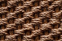 Close-up macro view of brown woven rope texture showing intricate diagonal pattern and natural fiber details. Seamless repeating background for design projects.