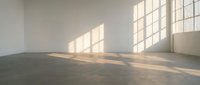 Empty minimalist interior room with large windows casting natural sunlight shadows on polished concrete floor for modern architectural design projects.