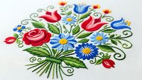 Colorful embroidered floral bouquet with red roses, blue daisies and green leaves on white fabric. Traditional folk art needlework design for textile decoration.
