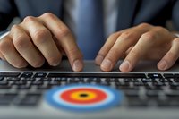 Male hands typing on laptop keyboard with target symbol, focusing on business goals and precision in digital marketing strategy. Close up view.