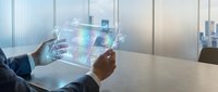 Businessman using transparent tablet with holographic financial data analytics in modern office boardroom for business intelligence and digital transformation.
