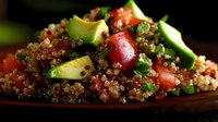 Fresh quinoa salad with diced avocado, red bell peppers and herbs on wooden serving board. Healthy superfood meal for clean eating and nutrition.