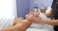 Professional spa facial massage therapy session with relaxed woman receiving skincare treatment from therapist in wellness center for rejuvenation and beauty.