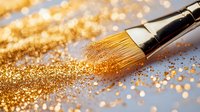 Makeup brush with scattered gold glitter powder on soft blue background, creating magical sparkle effect with bokeh lights for cosmetic and beauty concepts.