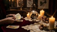 Fortune teller reading tarot cards with crystal ball and candles in mystical atmosphere for divination and spiritual guidance sessions.