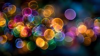 Vibrant colorful bokeh lights creating magical rainbow circles on dark background for festive celebrations, party decorations and holiday designs.