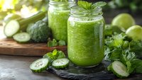 Fresh green smoothie in mason jar with cucumber, broccoli and mint leaves on rustic wooden board. Healthy detox drink for weight loss and wellness lifestyle.