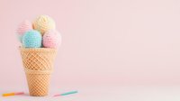 Colorful yarn balls arranged as ice cream scoops in waffle cone against pink background with knitting needles, creative crafting concept for knitters and crocheters.