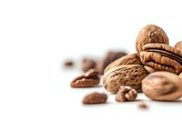 Mixed nuts and coffee beans on white background with copy space, selective focus on pecan and walnut shells, natural healthy snack ingredients for food design.