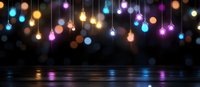 Glowing colorful light bulbs hanging against dark background with water reflection creating festive atmosphere for celebration and holiday design.