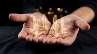 Human resources management concept with glowing golden figures floating above open palms representing team leadership and employee care.