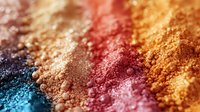 Vibrant crushed makeup pigments in rainbow colors from blue to orange create artistic gradient texture, macro close-up of cosmetic powder particles on surface.
