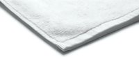 Soft white cotton terry towel folded neatly, isolated on white background, showcasing fluffy texture and clean minimalist design.