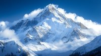 Majestic snow-covered mountain peak rising above clouds with dramatic lighting, rugged terrain, and pristine white slopes against deep blue sky. Perfect for adventure themes.