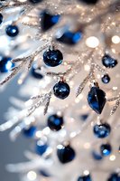 Sparkling silver branches adorned with deep blue ornaments create elegant holiday atmosphere against soft bokeh lights and frosty winter background.