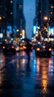 Blurred city street at night with colorful bokeh lights reflecting on wet pavement during rain, creating atmospheric urban scene for backgrounds and mood concepts.