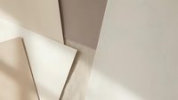 Overlapping neutral tone paper sheets and wooden surface creating geometric abstract composition with natural light and shadows for design projects.