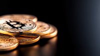 Shiny golden cryptocurrency coins stacked against dark background with dramatic lighting and selective focus creating modern financial concept.