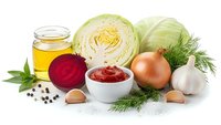 Fresh vegetables and cooking ingredients including cabbage, beetroot, onion, garlic, dill and olive oil arranged on white background for healthy meal preparation.