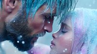 Romantic couple in winter scene with snowflakes, close-up profile view showing tender moment. Woman with pink hair and man with blue hair against blurred snowy background.