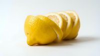 Fresh lemon sliced into fan arrangement on white background, showcasing vibrant yellow citrus fruit for food and healthy lifestyle concepts.