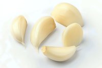 Fresh peeled garlic cloves isolated on white background, macro view showing smooth texture and natural ivory color. For cooking and food photography.