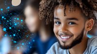 Young African American man with curly hair and beard smiling warmly against blurred background with glowing blue bokeh lights creating magical atmosphere.