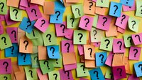Colorful sticky notes with question marks creating vibrant pattern background. Multiple adhesive papers in pink, blue, orange and green shades arranged chaotically.