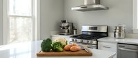 Fresh vegetables on wooden cutting board in modern kitchen with stainless steel appliances and natural light from window, suitable for food, cooking, and home design projects.