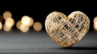 Golden wire heart sculpture with warm bokeh lights creating romantic atmosphere for Valentine's Day, wedding, love concepts and greeting cards.