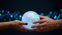 Two hands holding glowing digital globe with circuit board patterns against dark background with bokeh lights, representing global technology, data sharing, and digital connectivity.