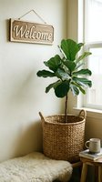 Cozy home corner with fiddle leaf fig in woven basket, welcome sign, and natural decor creating a warm, inviting entryway atmosphere.