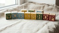 Colorful vintage wooden alphabet blocks spelling WORKSHOP arranged in a row on linen fabric, soft natural light, education and creativity concept.
