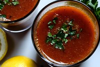Rich tomato broth soup garnished with fresh herbs in ceramic bowls, healthy comfort food meal ready to serve for lunch or dinner recipes.