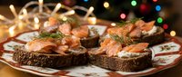 Festive smoked salmon appetizers on dark bread with cream cheese and dill garnish, perfect for holiday entertaining and Christmas celebrations.