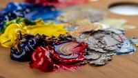 Artist oil paint palette with vibrant mixed colors on wooden surface for creative painting and artistic expression projects.