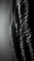 Close-up monochrome shot of flowing dark hair strands with glossy texture and fine detail, suitable for beauty, haircare, and wellness marketing materials.