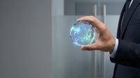 Businessman in suit holding glowing blue digital sphere with futuristic holographic interface in modern office environment for technology presentations.