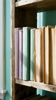 Vintage books with colorful spines arranged on rustic wooden bookshelf for cozy home library and reading corner interior design.