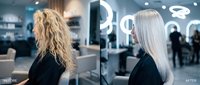 Professional hair transformation from curly blonde to sleek straight platinum in modern salon setting with before and after comparison.