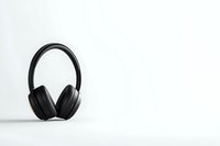 Black wireless headphones on white background with shadow reflection, minimalist composition for audio equipment advertising and music lifestyle concept.