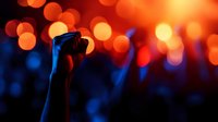 Concert crowd silhouettes with hands raised against vibrant orange bokeh lights creating energetic live music atmosphere for entertainment design.