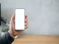 Person holding smartphone with blank white screen for app mockup or mobile interface design presentation.