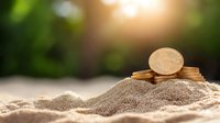 Golden bitcoin cryptocurrency coin stack on beach sand with natural sunlight bokeh background, digital money investment concept.