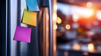 Colorful sticky notes on metal surface with blurred bokeh lights background creating modern office atmosphere. Suitable for business and productivity concepts.