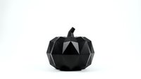 Black geometric pumpkin with angular faceted surface and stem isolated on white background for modern Halloween decoration and autumn design projects.