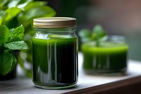 Fresh green smoothie in glass jar with mint leaves on wooden table, healthy detox drink for wellness and nutrition lifestyle.